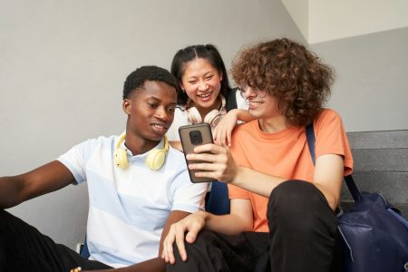 Group of teenage students of different ethnicities sitting on the stairs of the university Group of teenage students of different ethnicities sitting on the stairs of the university
